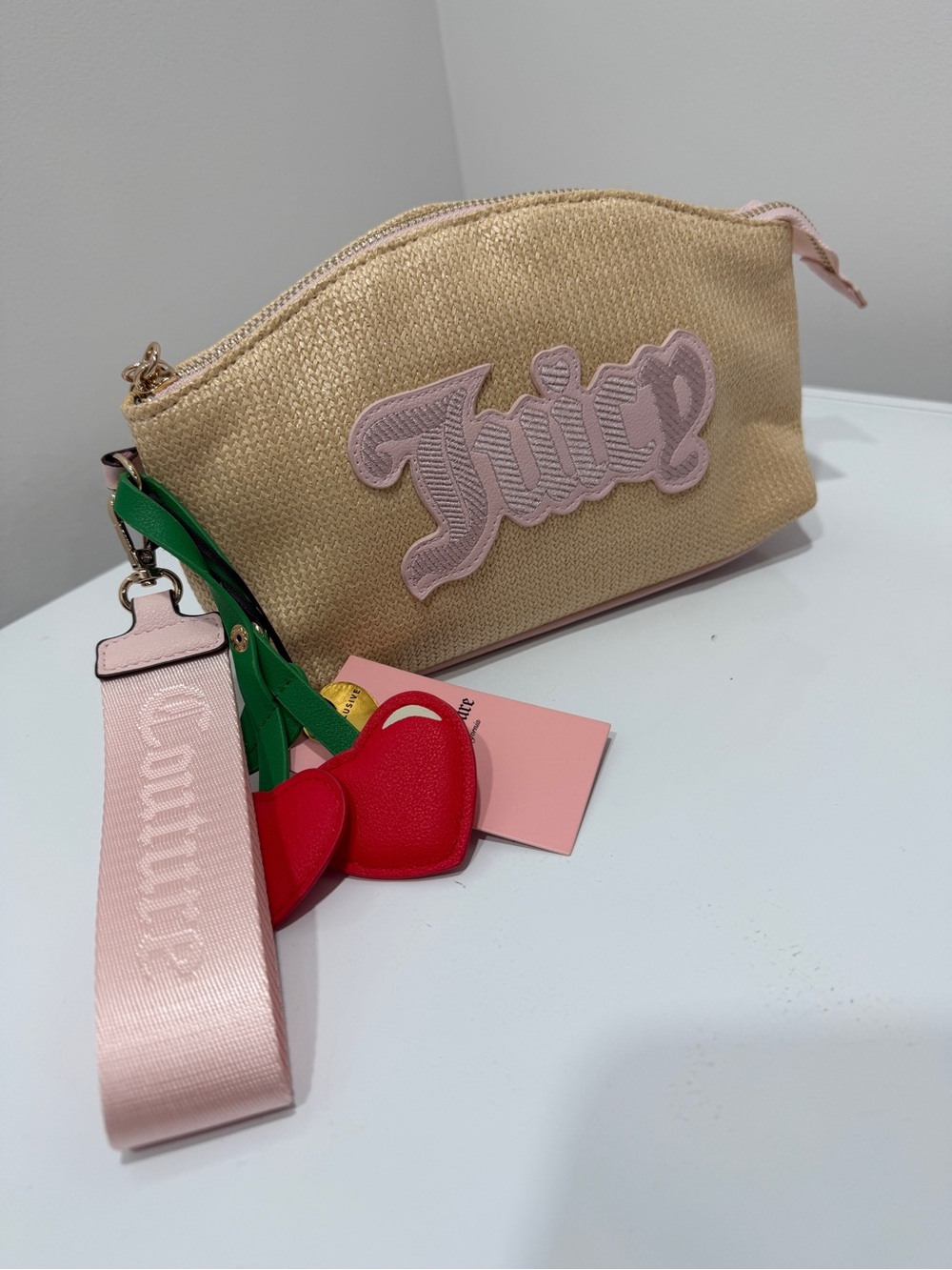 Juicy Couture gold straw clutch with pink logo and red heart charm